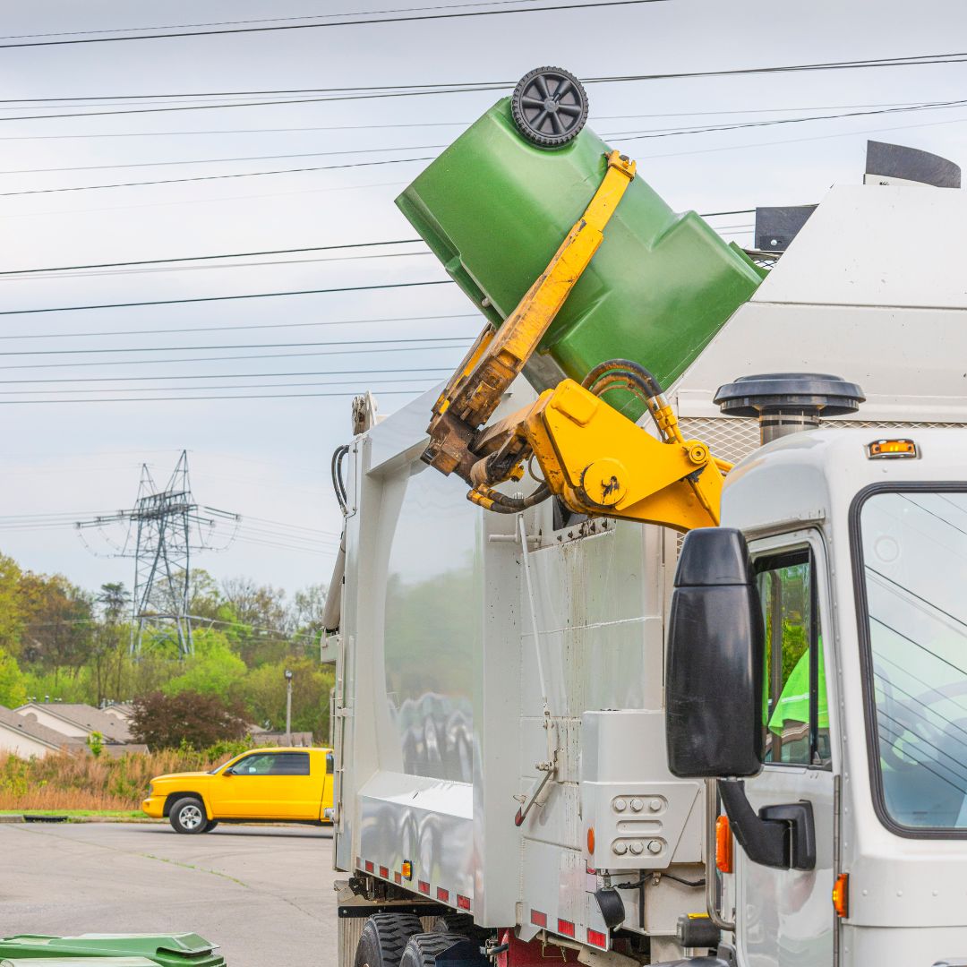 a trash truck dumping a trash can